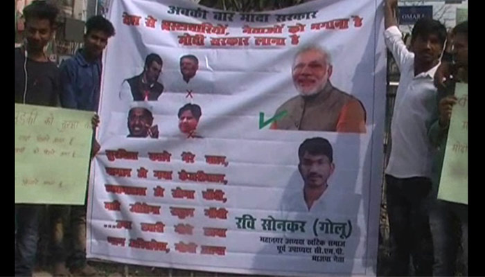 PICTURES: BJP workers paste posters violating the model code of conduct